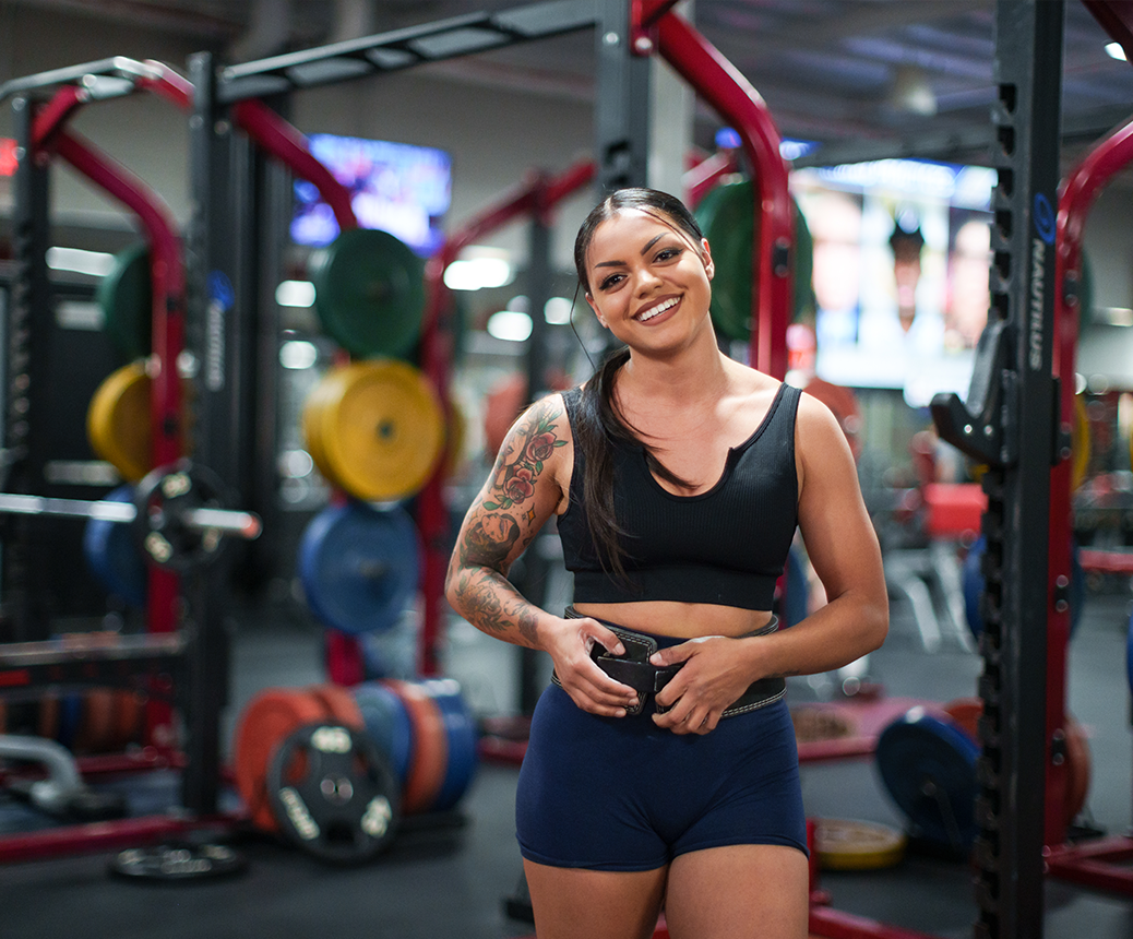 photo of two women in workout clothing squatting in gym