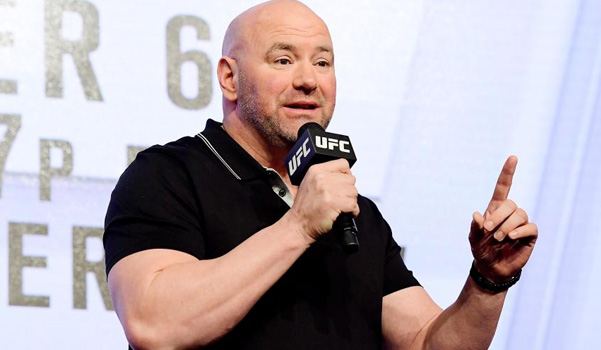 photo of man in black shirt talking into microphone with UFC logo