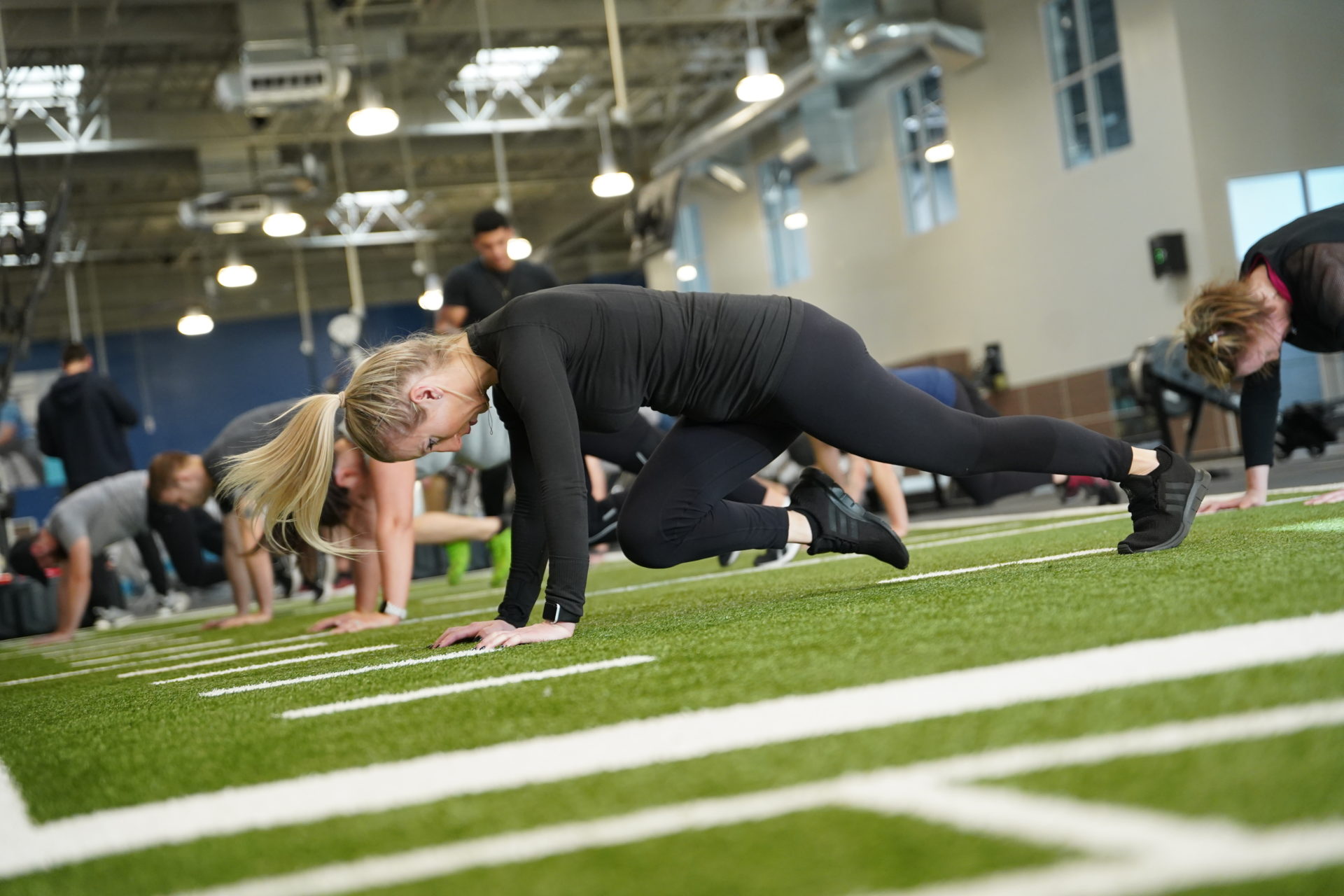 photo of women working out on green turf