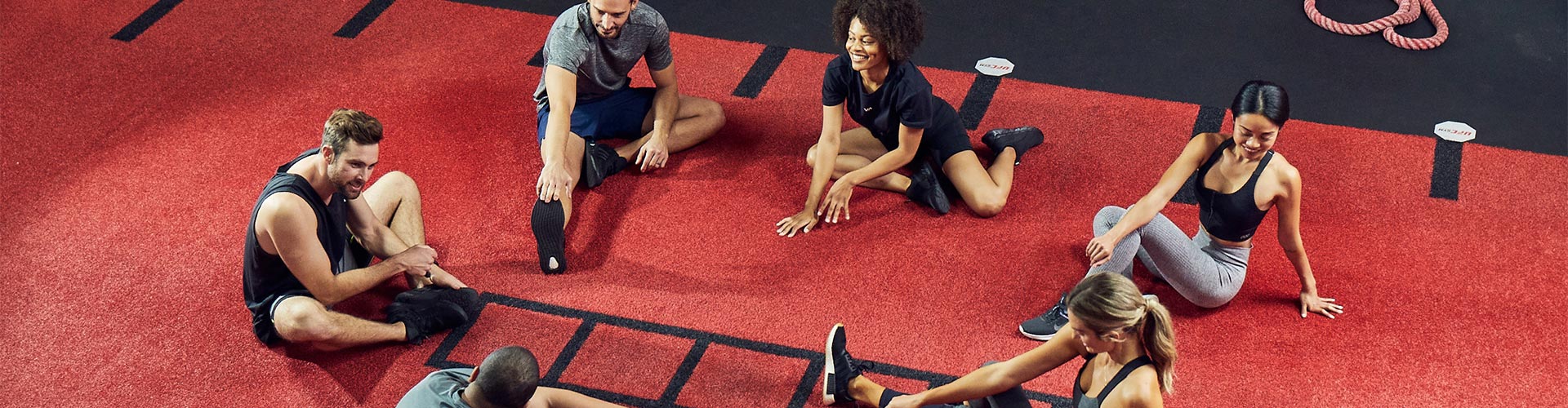 photo of group of women and men stretching in gym