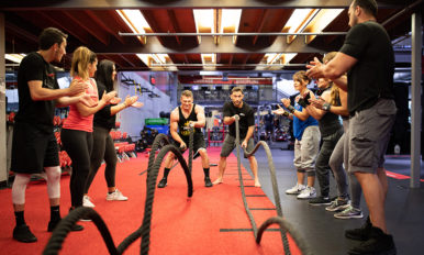 Image of group of gym members working out with ropes in a UFC GYM